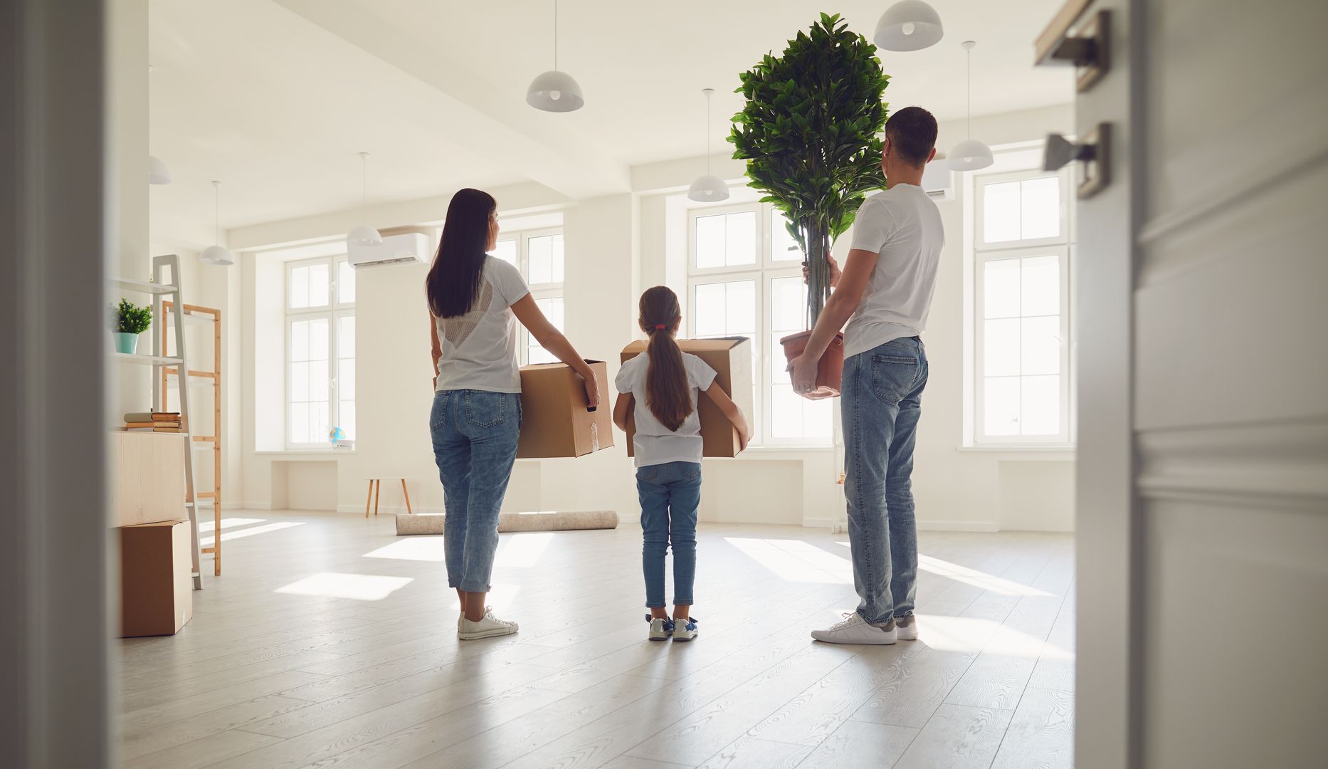 Eine Familie mit Umzugskartons in einer leeren Wohnung